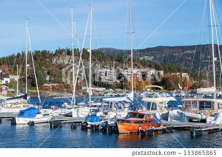 A peaceful harbor scene with sailboats moored at a marina, Norway 133865865