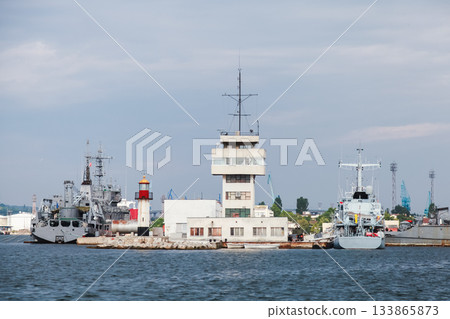 Varna naval harbor view featuring warships docked beside a modern control tower 133865873