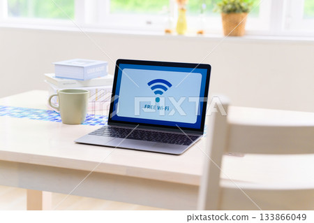 Free Wi-Fi sign displayed on a laptop screen and desk area 133866049