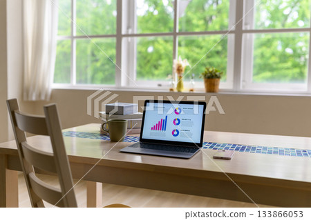 窗邊明亮的桌子上擺著一台用於數據分析的筆記型電腦。 133866053