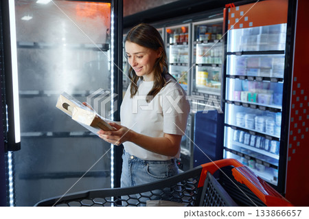 A woman is examining a box that she found in a store 133866657