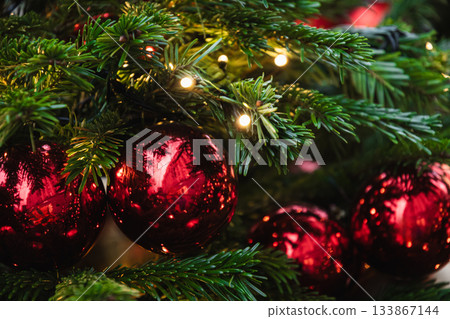 Christmas tree decorated red balls and lights garland. Xmas holiday spirit. Winter. Outdoors. 133867144