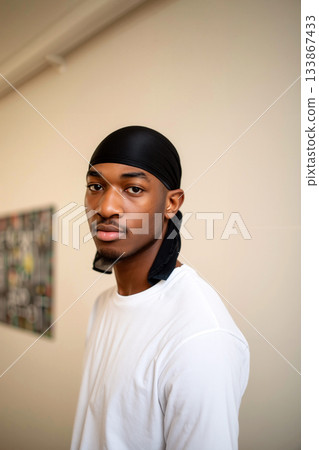 Portrait of a Young Man in a Black Durag Wearing a White Shirt Indoors With Subtle Background Elements 133867433