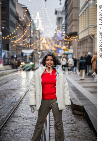 indian woman walking on festive street with christmas lights in helsinki 133867549