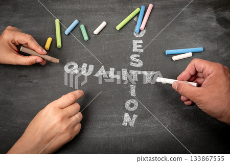 Quality and Question Concept Written with Chalk on Blackboard by Two People Quality and Question Concept Written with Chalk on Blackboard by Two People 133867555