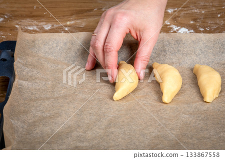 Placing Unbaked Pastries on Parchment Paper Lined Baking Tray Before Baking 133867558