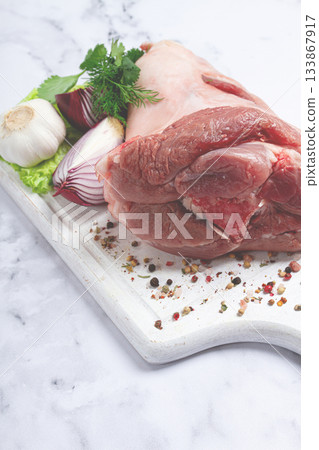 Raw pork knuckle, on a wooden chopping board, with spices, close-up, top view, no people, 133867917