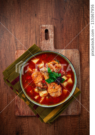 Souzi soup. Georgian dish, meat with oats, tomato sauce and herbs, on a wooden table Souzi soup. Georgian dish, meat with oats, tomato sauce and herbs, on a wooden table 133867956