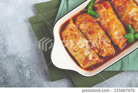 Stuffed cabbage rolls with minced meat, in tomato sauce, top view, without people, in the spotlight. 133867970