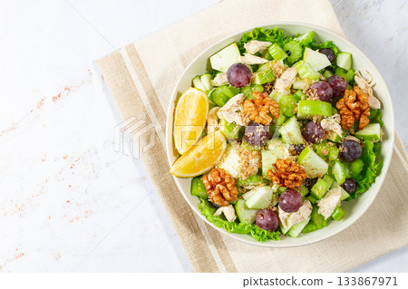 Fresh Waldorf salad, celery stalk with chicken, apple and walnuts, grapes, herbs, homemade, without people, 133867971