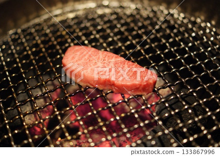 A sizzle shot of juicy marbled lean meat grilled over a charcoal grill A sizzle shot of juicy marbled lean meat grilled over a charcoal grill 133867996