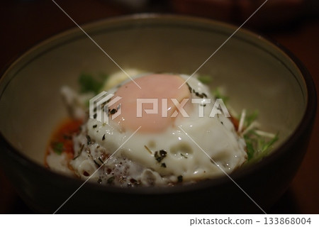 A colorful lunch of Loco Moco rice bowl topped with a soft-boiled fried egg and vegetables 133868004