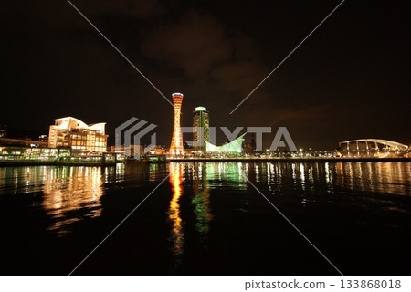 The illuminated Kobe Port Tower and cityscape shining in the harbor at night The illuminated Kobe Port Tower and cityscape shining in the harbor at night 133868018