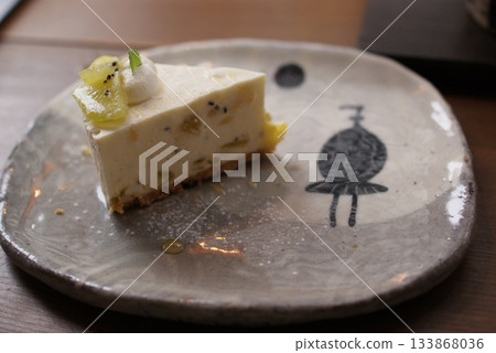A slice of refreshing cheesecake decorated with kiwi and cream A slice of refreshing cheesecake decorated with kiwi and cream 133868036