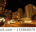 The shining hotels in the night cityscape and the bustling cityscape depicted by the tracks of cars 133868078