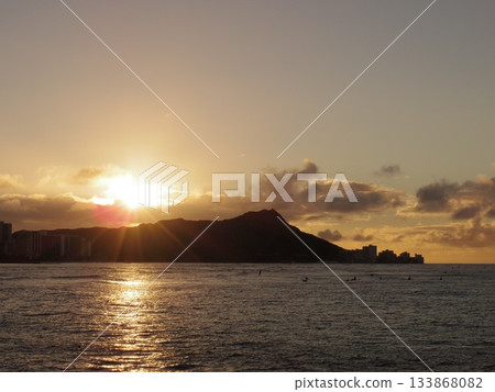 The golden sea surface and silhouette reflected by the setting sun behind the mountains The golden sea surface and silhouette reflected by the setting sun behind the mountains 133868082