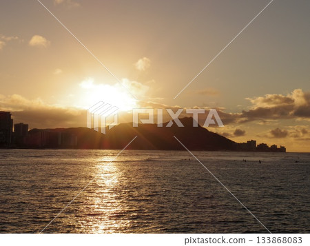 A dramatic scene created by the golden sea and the sunset over the mountains A dramatic scene created by the golden sea and the sunset over the mountains 133868083