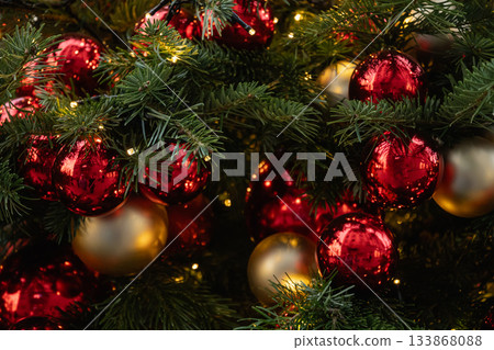 Christmas tree decorated red balls and lights garland. Xmas holiday spirit. Winter. Outdoors. 133868088