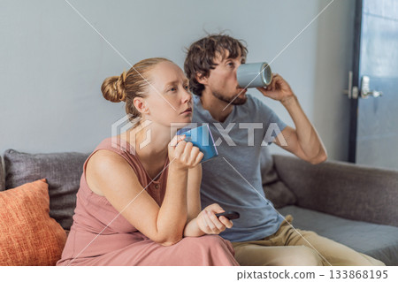 Woman and man relaxing together on the sofa while watching a movie on television, enjoying a cozy evening at home. Lifestyle, bonding and entertainment concept, showing comfort, togetherness and Woman and man relaxing together on the sofa while watching a movie on television, enjoying a cozy evening at home. Lifestyle, bonding and entertainment concept, showing comfort, togetherness and 133868195