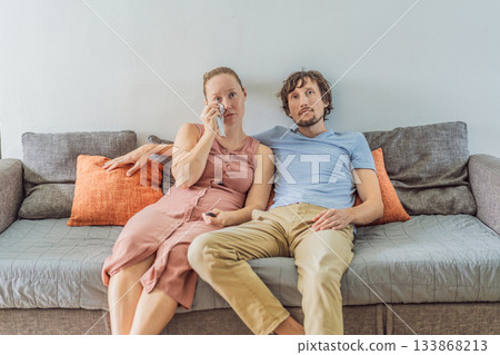 Woman and man relaxing together on the sofa while watching a movie on television, enjoying a cozy evening at home. Lifestyle, bonding and entertainment concept, showing comfort, togetherness and 133868213