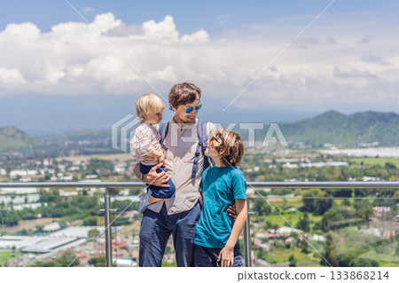 Father with his two sons standing in front of Popocatepetl volcano in Mexico, surrounded by clouds, enjoying a scenic family adventure and breathtaking outdoor view Father with his two sons standing in front of Popocatepetl volcano in Mexico, surrounded by clouds, enjoying a scenic family adventure and breathtaking outdoor view 133868214