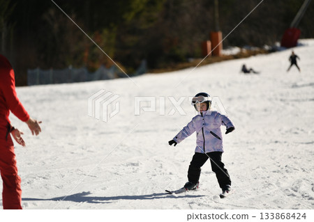 Ski coach giving a lesson to a child 133868424