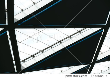 A geometric abstraction featuring large black triangular shapes and thin blue stripes along the perimeter, parallel lines, made of metal. Horizontal photo A geometric abstraction featuring large black triangular shapes and thin blue stripes along the perimeter, parallel lines, made of metal. Horizontal photo 133868494