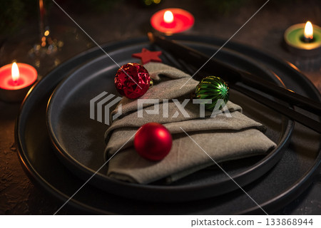 Christmas Table Setting with Tree-Shaped Napkin, Utensils, Ornaments and Tealight Candles Christmas Table Setting with Tree-Shaped Napkin, Utensils, Ornaments and Tealight Candles 133868944