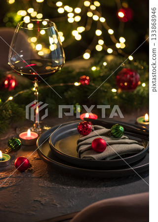 Christmas Table Setting with Tree-Shaped Napkin and Tealight Candles against Christmas lights Christmas Table Setting with Tree-Shaped Napkin and Tealight Candles against Christmas lights 133868946