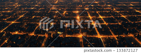 Aerial view of a sprawling metropolis at night, revealing a grid pattern of streets illuminated by warm toned city lights, showcasing the urban landscape Aerial view of a sprawling metropolis at night, revealing a grid pattern of streets illuminated by warm toned city lights, showcasing the urban landscape 133872127