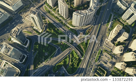 Aerial view of a complex highway interchange weaving its way through a dense urban environment, showcasing the intricate network of roads, bridges, and surrounding skyscrapers Aerial view of a complex highway interchange weaving its way through a dense urban environment, showcasing the intricate network of roads, bridges, and surrounding skyscrapers 133872293