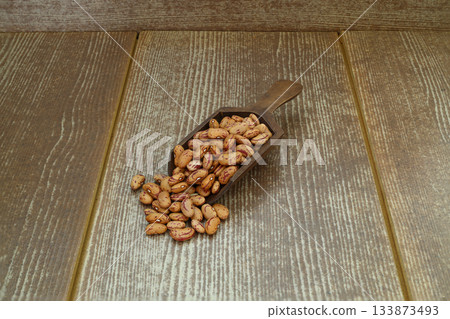 red kidney beans in wooden spoon isolated on dark background. red kidney beans in wooden spoon isolated on dark background. 133873493