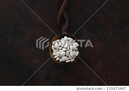 white kidney bean in wooden spoon isolated on wooden background. Top view. Flat lay 133873497