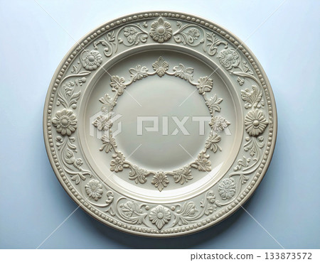 Classic patterns. Ceramic plate with a classic white design and floral border on a white background. Porcelain kitchenware. Close-up. Top view. 133873572