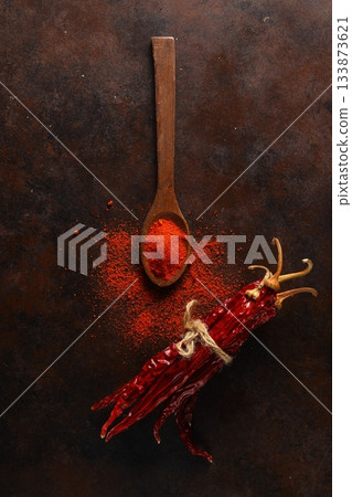 cayenne pepper on wooden spoon spices and dried chilli peppers background. cayenne pepper on wooden spoon spices and dried chilli peppers background. 133873621