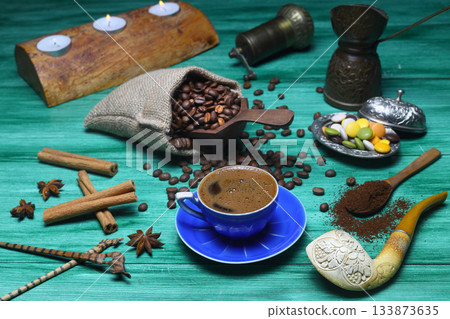 Turkish coffee concept. Copper pot (Cezve), vintage coffee grinder, coffee beans on a dark wooden background. 133873635
