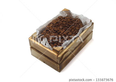 Closeup of roasted coffee beans in a small wooden crate, isolated on white background. Closeup of roasted coffee beans in a small wooden crate, isolated on white background. 133873676