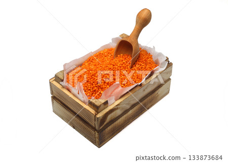 Red Lentil in a small wooden crate, isolated on white background. With Wooden Spoon. Red Lentil in a small wooden crate, isolated on white background. With Wooden Spoon. 133873684