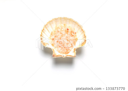 Himalayan salt in a seashell. Isolated on white background. Himalayan salt in a seashell. Isolated on white background. 133873770