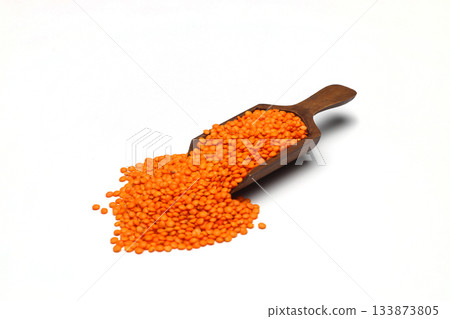 Red lentils in wooden scoop, isolated on white background. Red lentils in wooden scoop, isolated on white background. 133873805