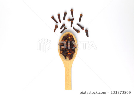 Dry cloves in wooden scoop isolated on white background with clipping path. Top view. Flat lay 133873809