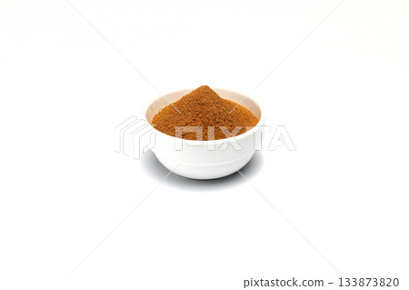 ground cinnamon in a bowl isolated on white background, close up 133873820