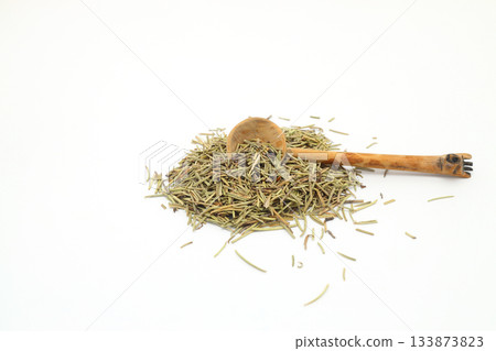 Closeup of dried rosemary on a wooden spoon isolated over white background. Closeup of dried rosemary on a wooden spoon isolated over white background. 133873823