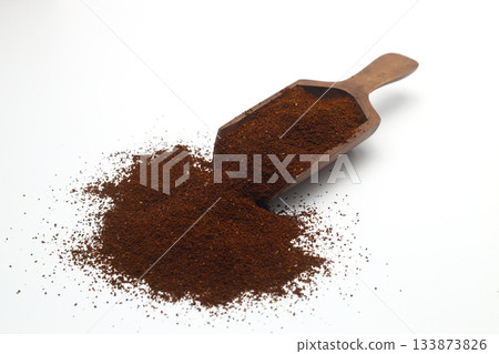 Coffee beans in a wooden scoop isolated on a white background. Roasted coffee beans isolated. A wooden scoop with coffee. 133873826