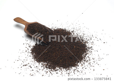 Dried black tea leaves in scoop isolated on white background. Dried black tea leaves in scoop isolated on white background. 133873841
