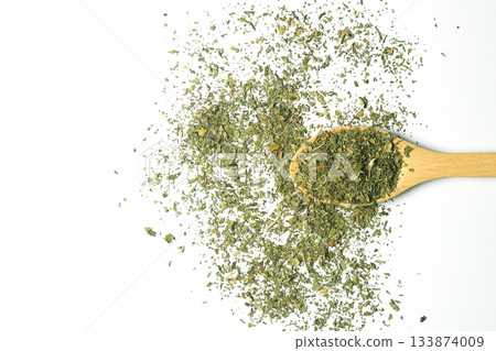 Dry mint in wooden spoon isolated on white background Dry mint in wooden spoon isolated on white background 133874009