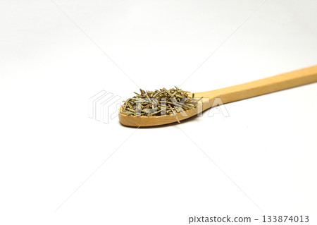 Closeup of dried rosemary on a wooden spoon isolated over white background. 133874013