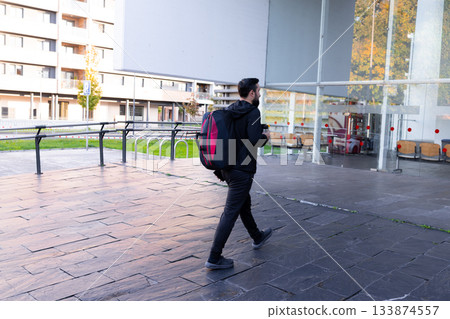 Young caucasian male goes to the entrance to the sports center Young caucasian male goes to the entrance to the sports center 133874557