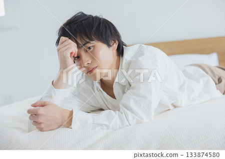 Young man relaxing in bedroom Young man relaxing in bedroom 133874580