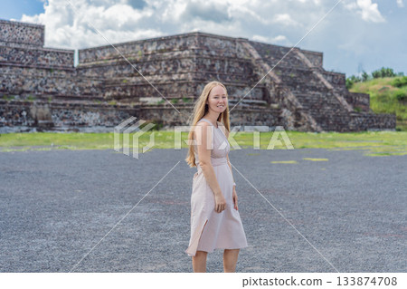 Female tourist standing in front of Teotihuacan pyramids in Mexico, enjoying sightseeing, adventure, and cultural heritage. Travel, tourism, and exploration concept 133874708